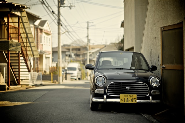 道路上に泊まっている軽自動車の画像